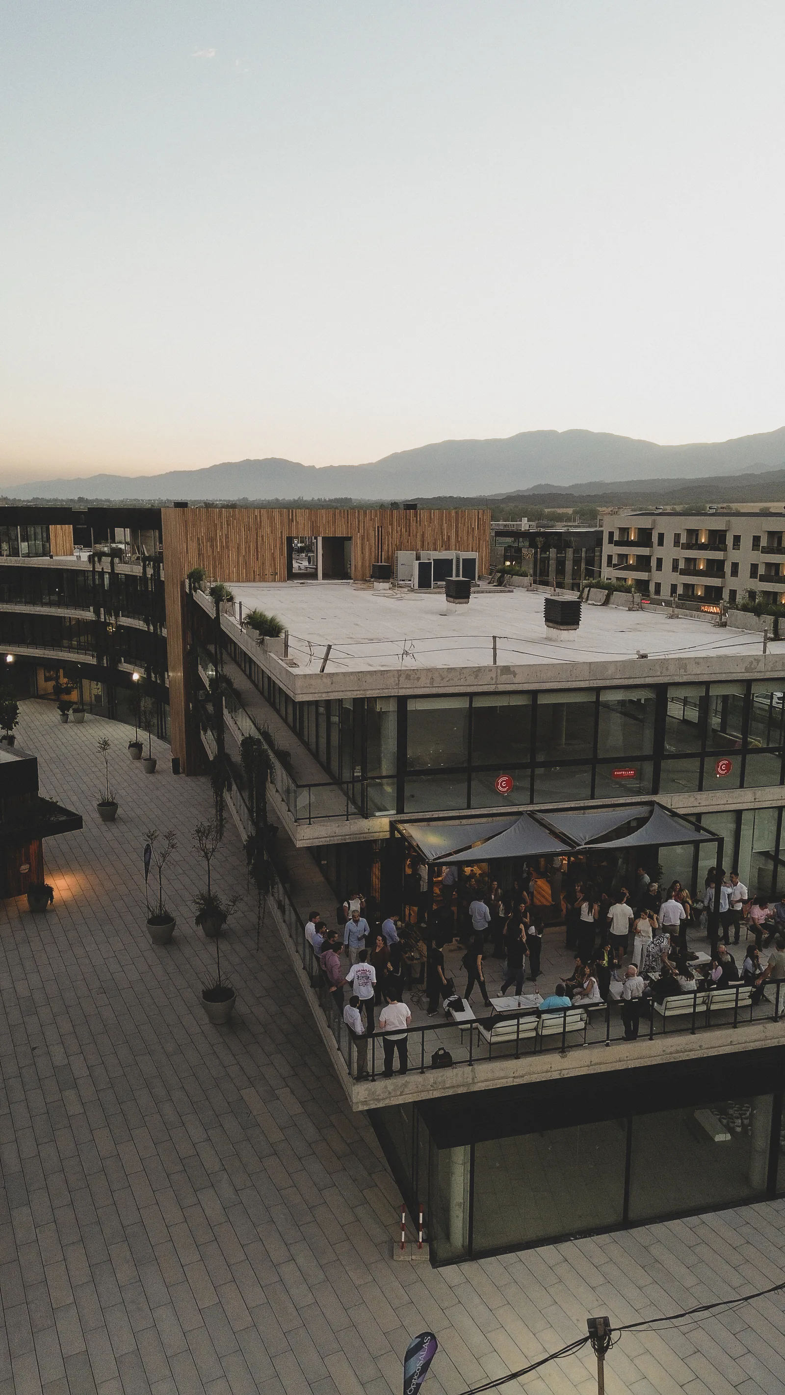 La terraza con el evento, vista desde un dron al atardecer, con los cerros al fondo