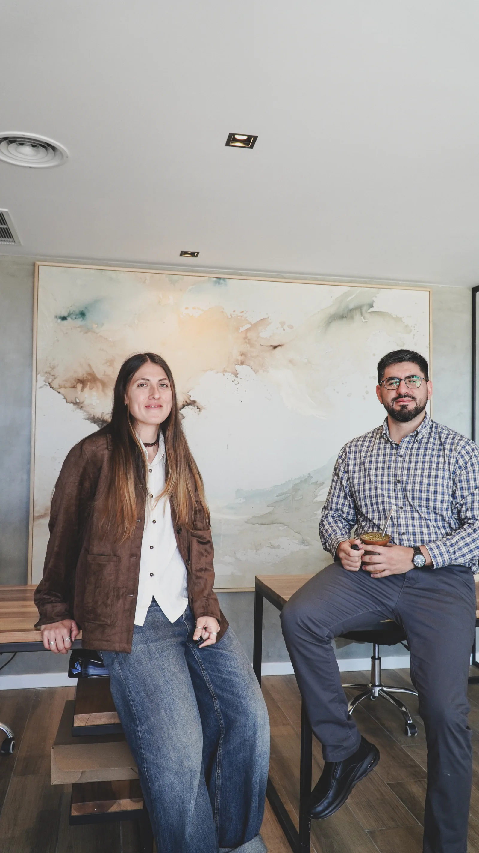 Dos integrantes de Mavenz en la oficina, sentados en banquetas