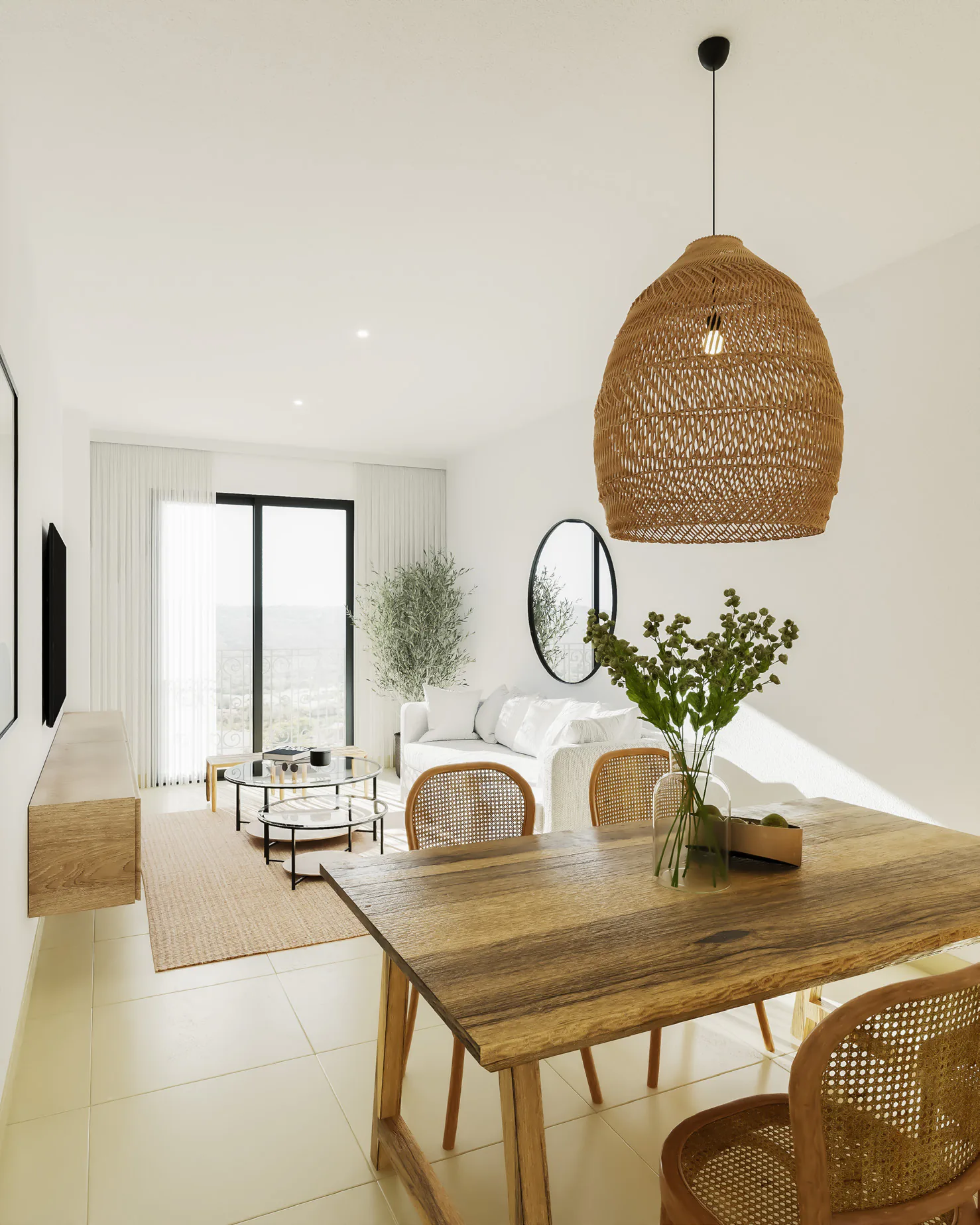 Comedor con mesa de madera, sillas de ratán y una lámpara colgante de fibra, con el living y el ventanal al fondo