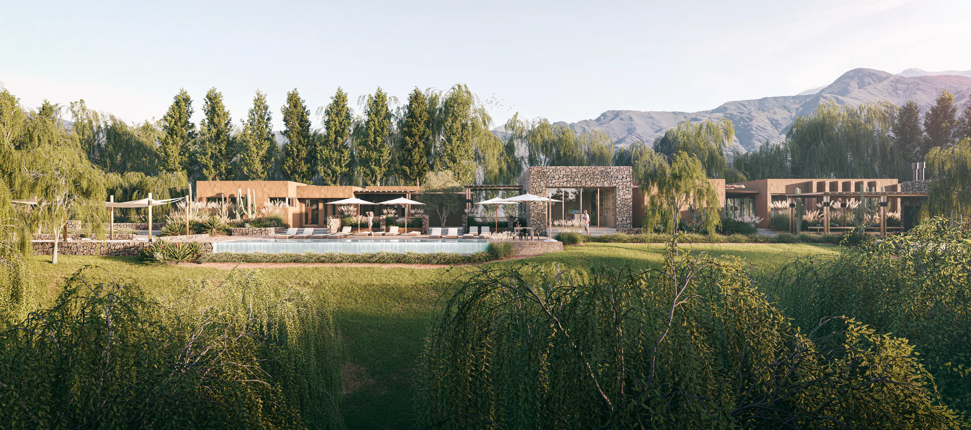 Casas bajas de tierra y piedra con pileta, entre álamos, sauces y cardones, con cerros al fondo