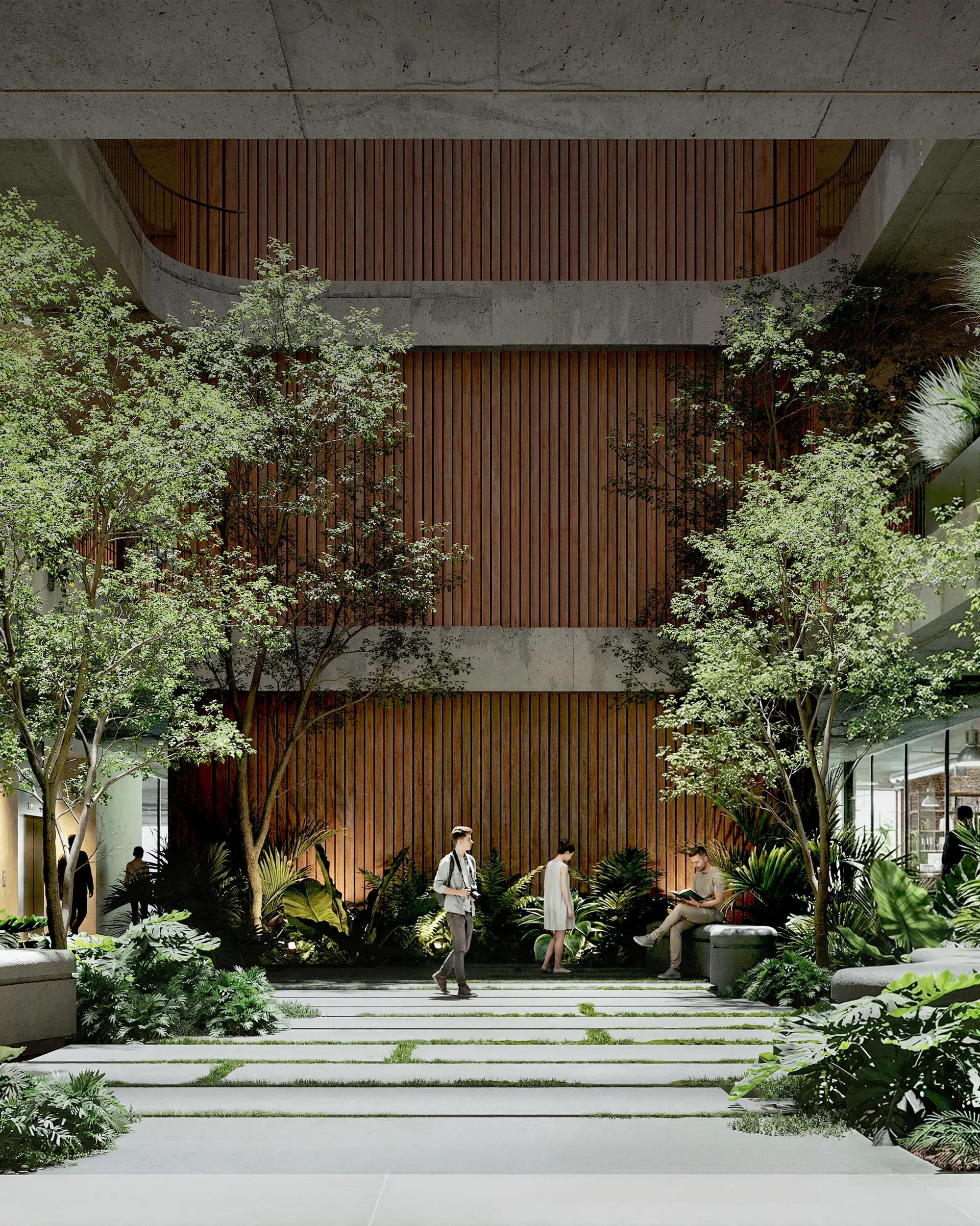 Patio interior de planta baja con árboles, plantas de hojas grandes y un camino de losetas con pasto, rodeado de oficinas vidriadas, con un muro de listones de madera que sube por el vacío del patio